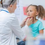 doctor-examining-young-girls-neck