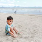 little-asian-baby-boy-relax-sand-beach_38678-6027